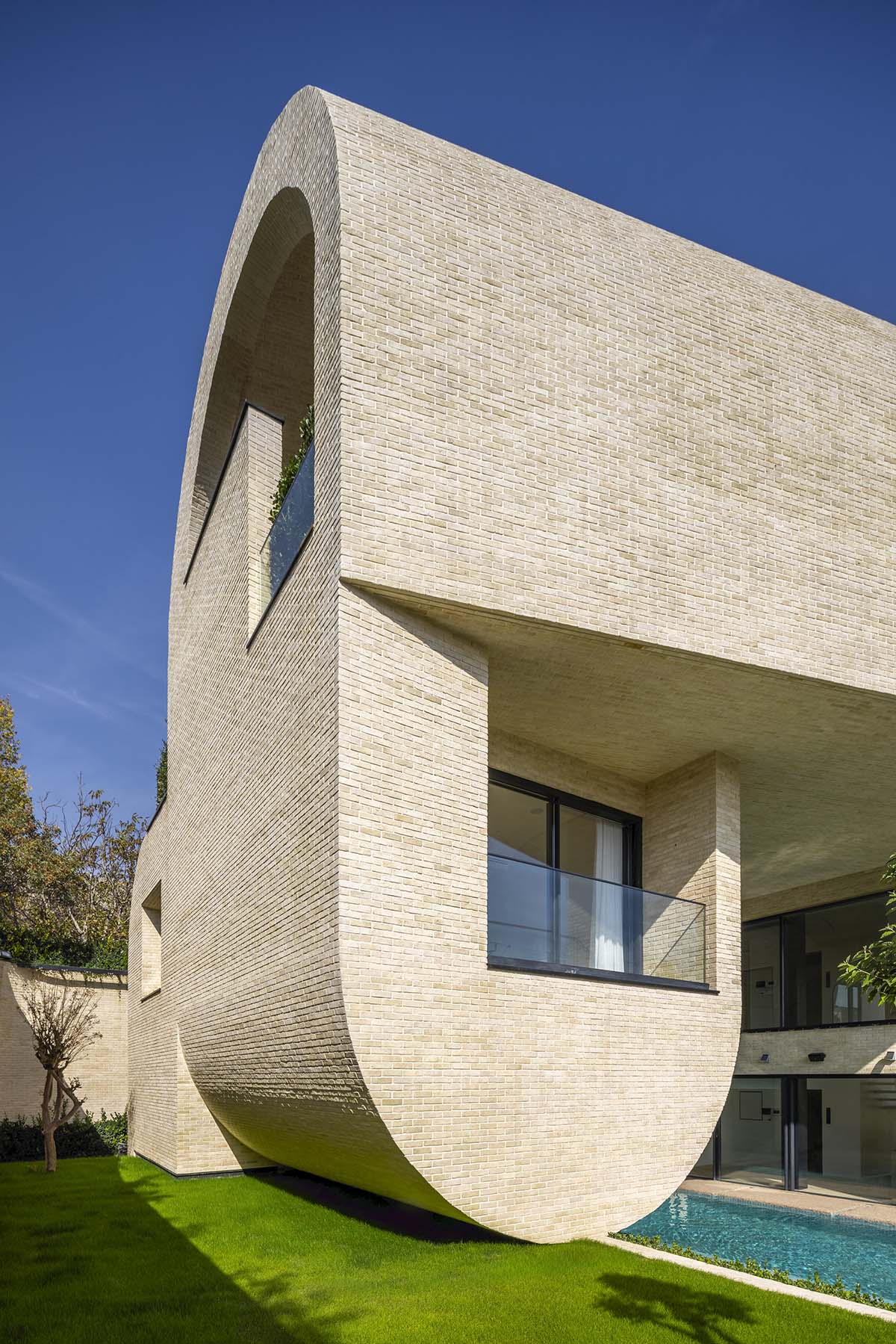 Tunnel-like villa is enhanced by reversed arch elements to define intricate courtyard in Iran