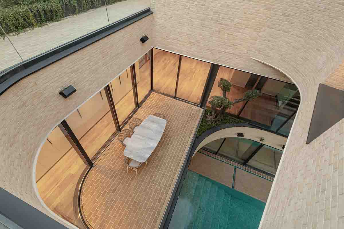 Tunnel-like villa is enhanced by reversed arch elements to define intricate courtyard in Iran