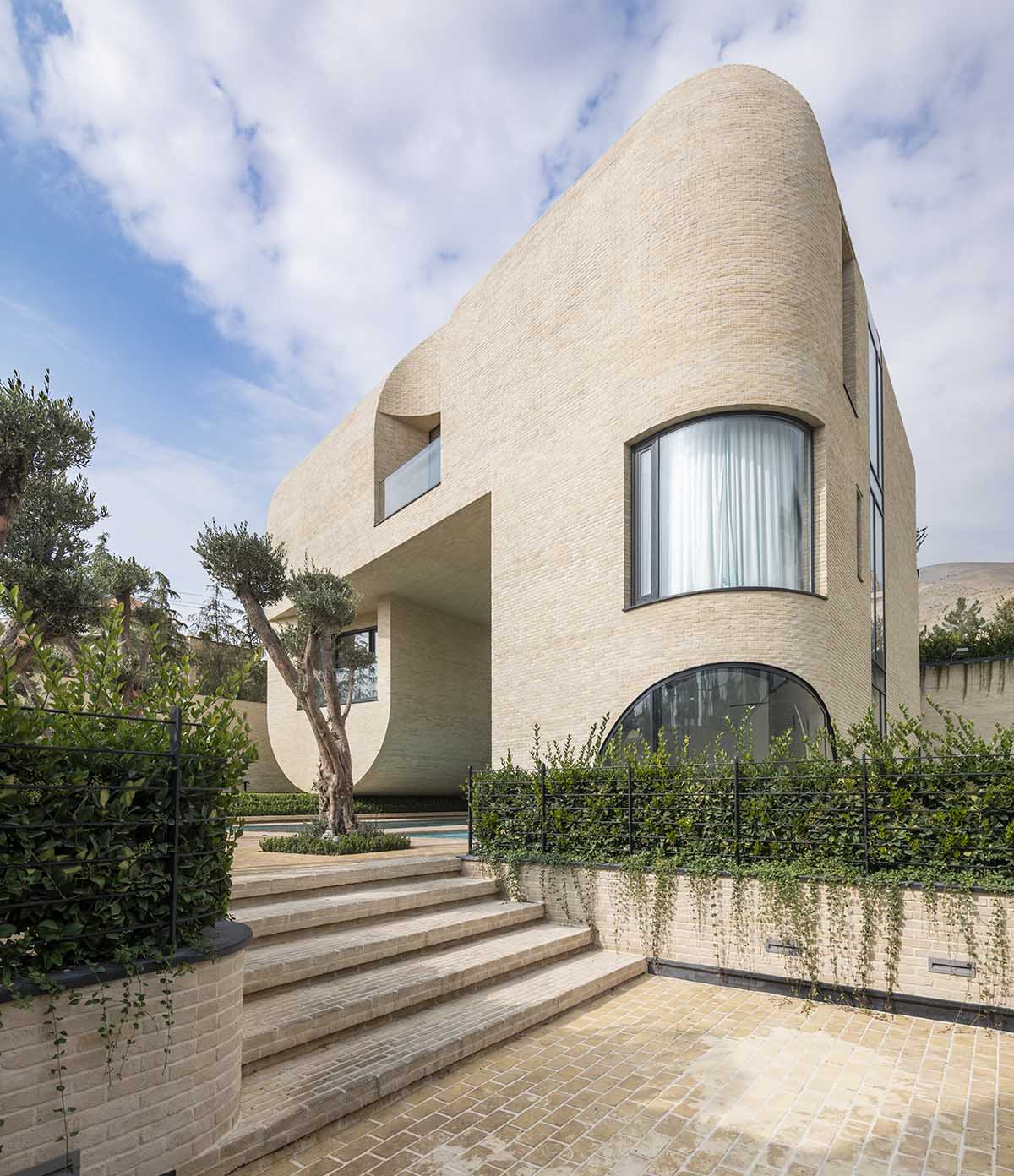 Tunnel-like villa is enhanced by reversed arch elements to define intricate courtyard in Iran