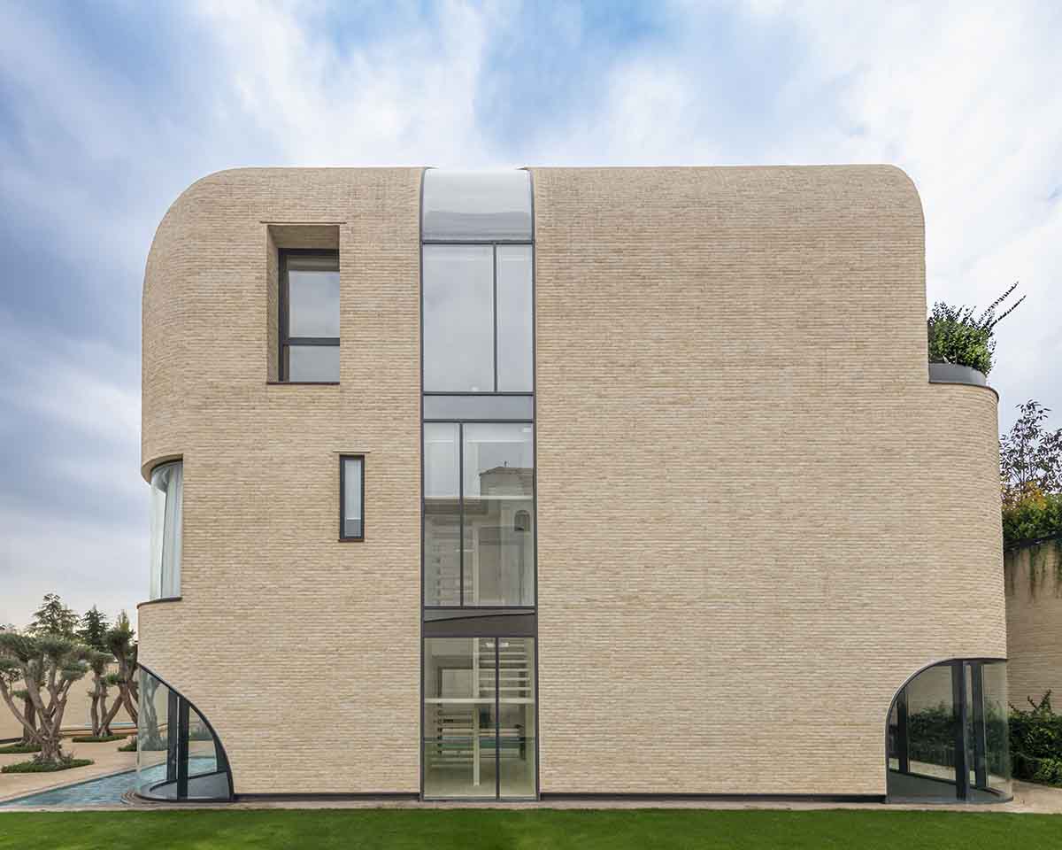 Tunnel-like villa is enhanced by reversed arch elements to define intricate courtyard in Iran