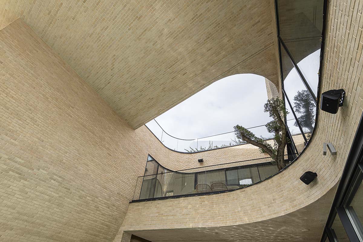 Tunnel-like villa is enhanced by reversed arch elements to define intricate courtyard in Iran