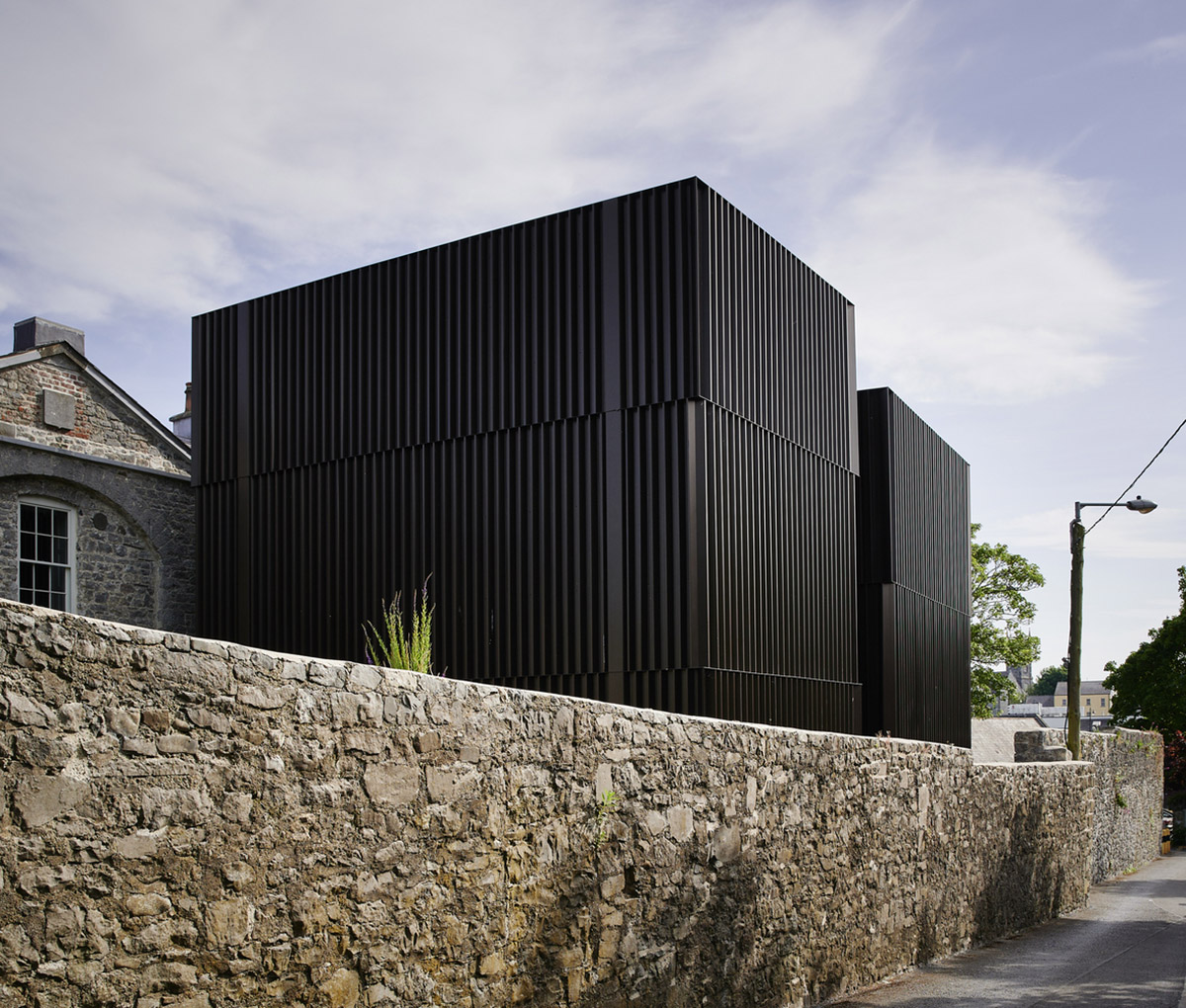 Mccullough Mulvin Architects adds two metal-clad volumes to convert former almshouse into art gallery