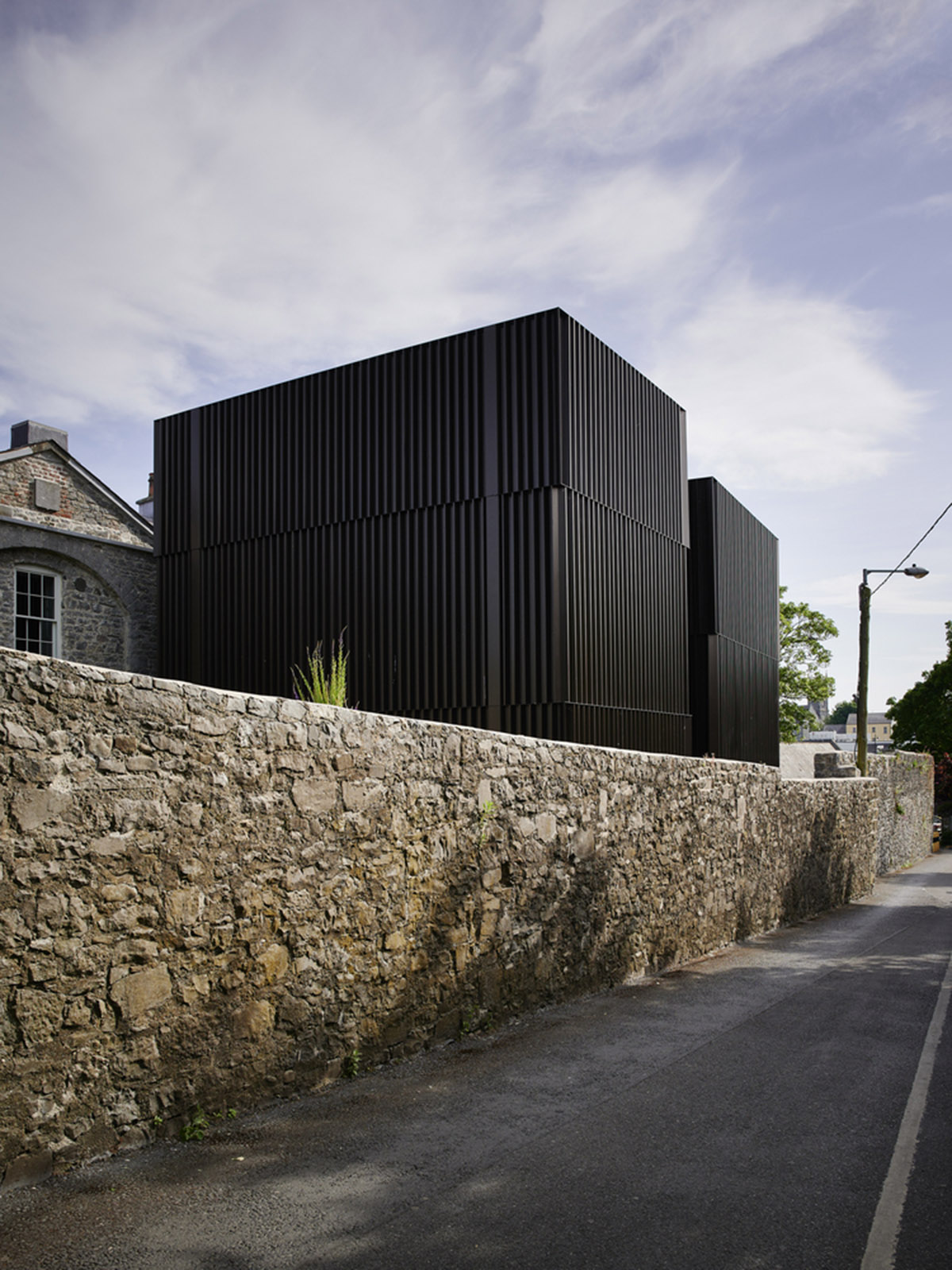 Mccullough Mulvin Architects adds two metal-clad volumes to convert former almshouse into art gallery
