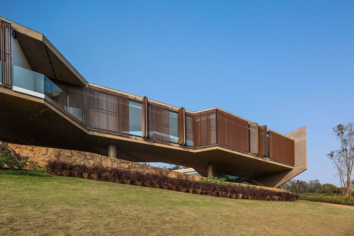 Bridge-like Brazilian house by Yuri Vital is supported by angular structural walls on sloped terrain