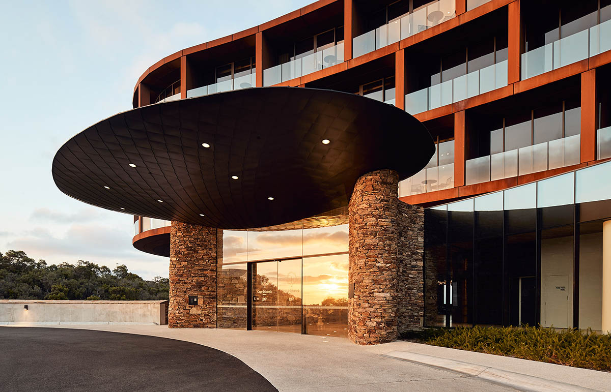 Wood Marsh completes sinuous resort anchored on hand-built locally sourced stone plinth in Australia
