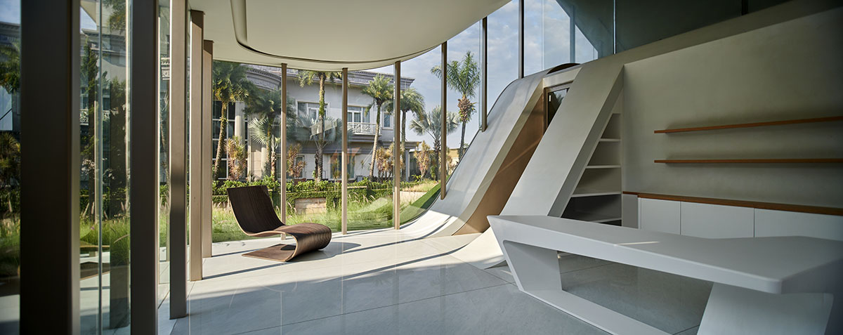 Undulating residence by RDMA is placed onto grass covered earth mound in Indonesia