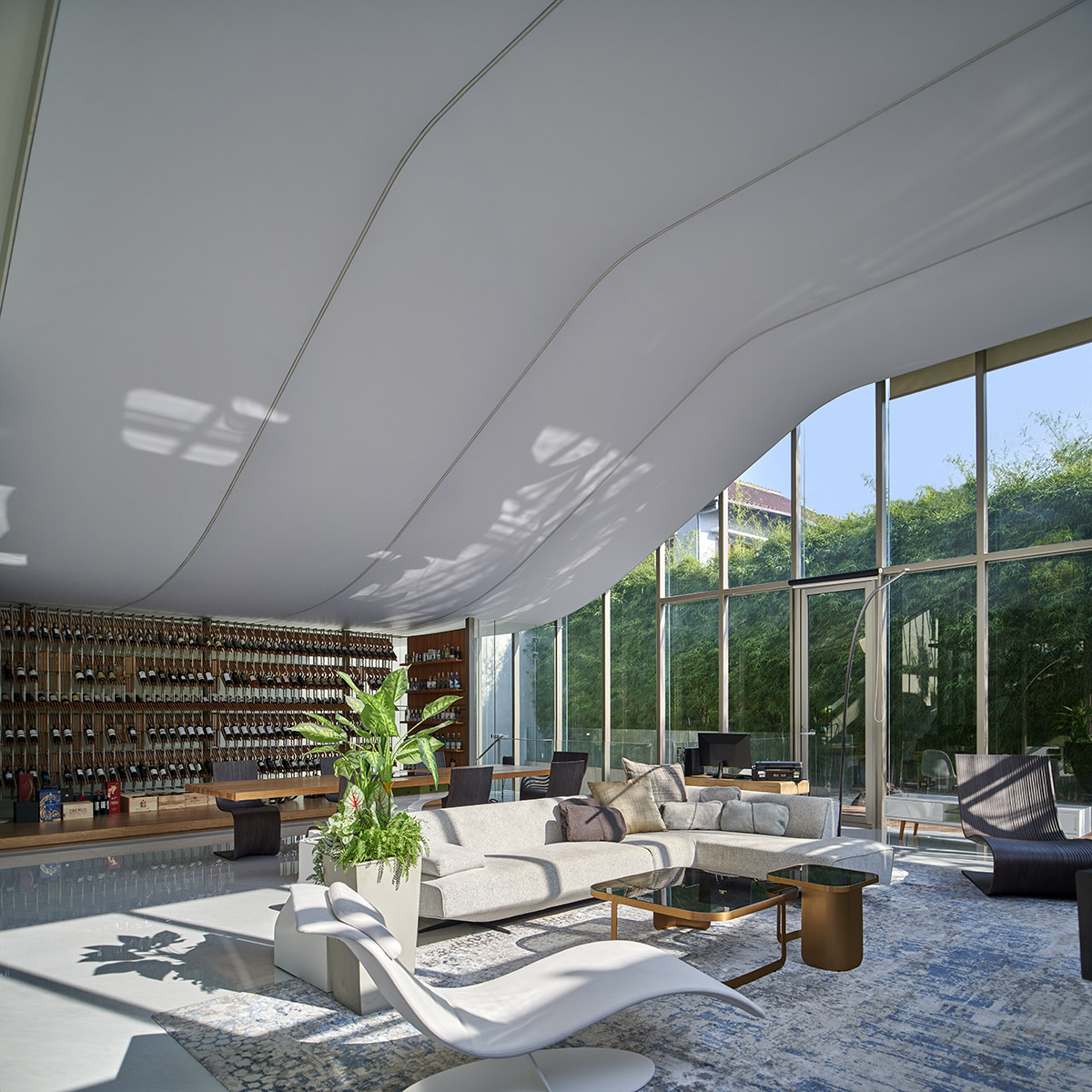 Undulating residence by RDMA is placed onto grass covered earth mound in Indonesia