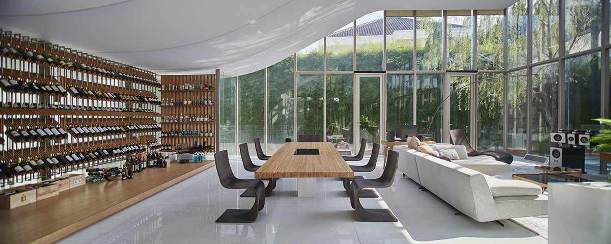 Undulating residence by RDMA is placed onto grass covered earth mound in Indonesia