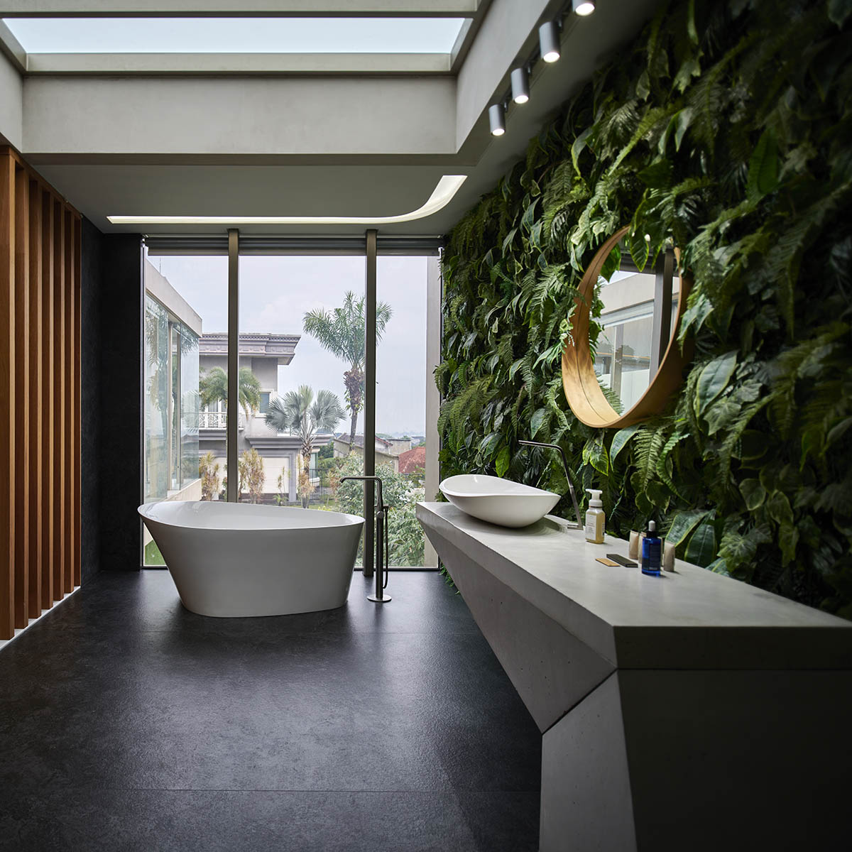 Undulating residence by RDMA is placed onto grass covered earth mound in Indonesia