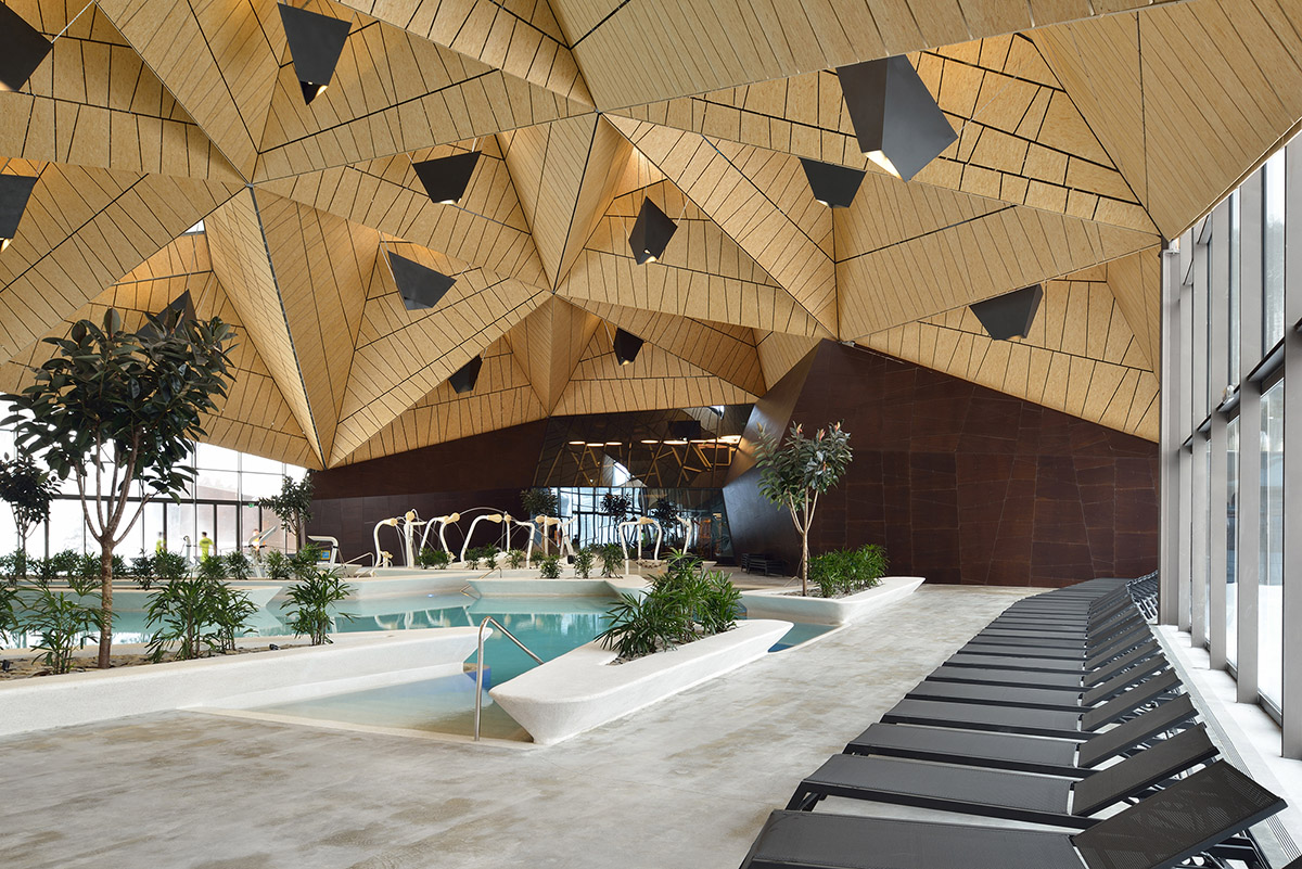 ENOTA's new spa complex made of tetrahedral volumes is spread as part of existing rural buildings