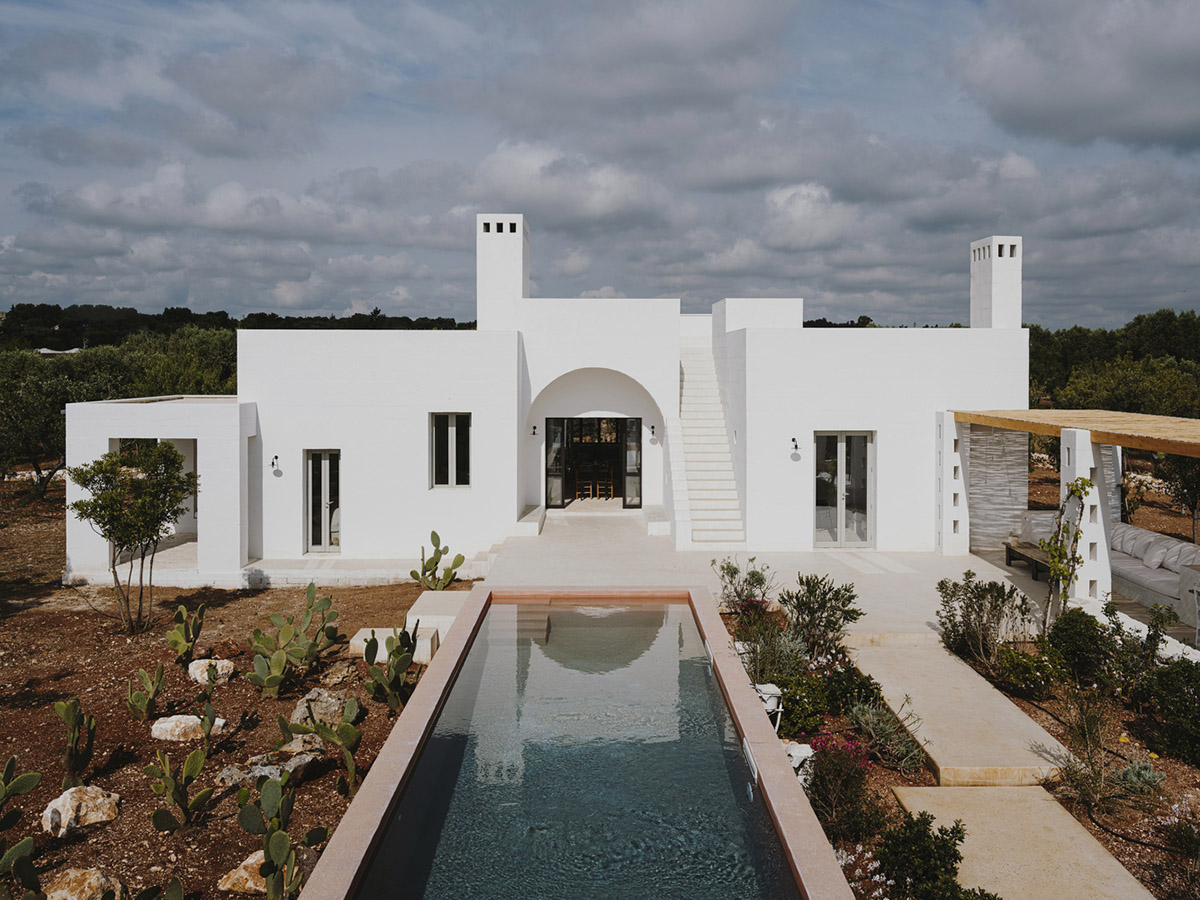 Villa Cardo featuring all-white walls looks like a small castle among olive trees in Carovigno