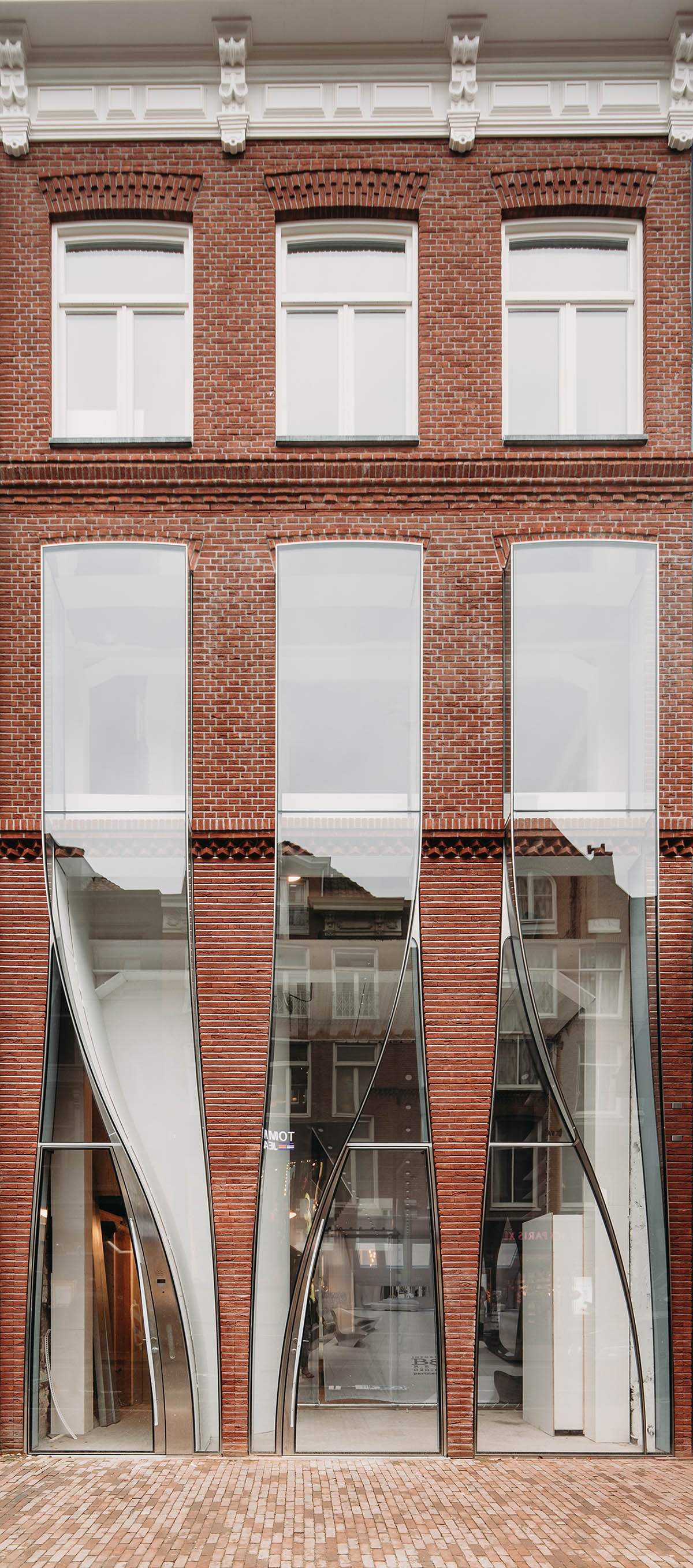 UNStudio combines curved glass panels with brickwork for Dutch flagship store in Amsterdam