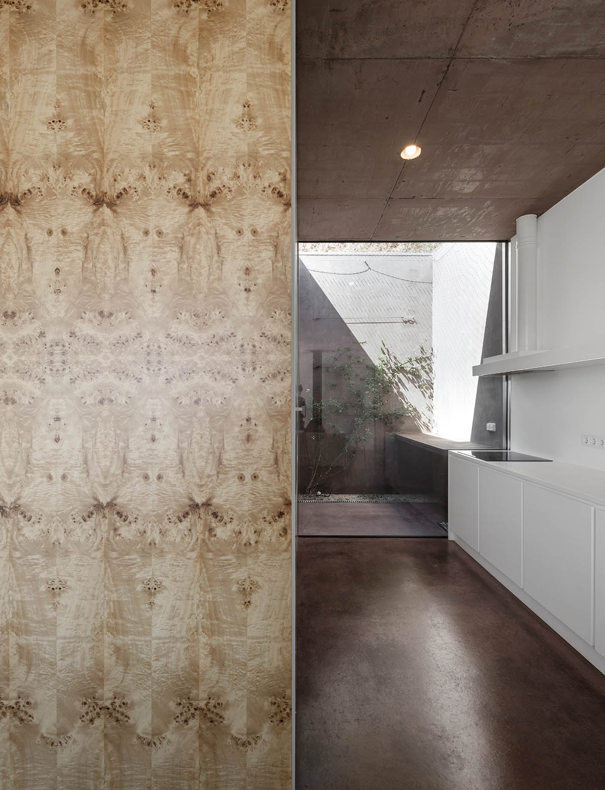 Earthy-toned twin houses by Extrastudio appear to emerge from the ground on a steep slope in Sesimbra