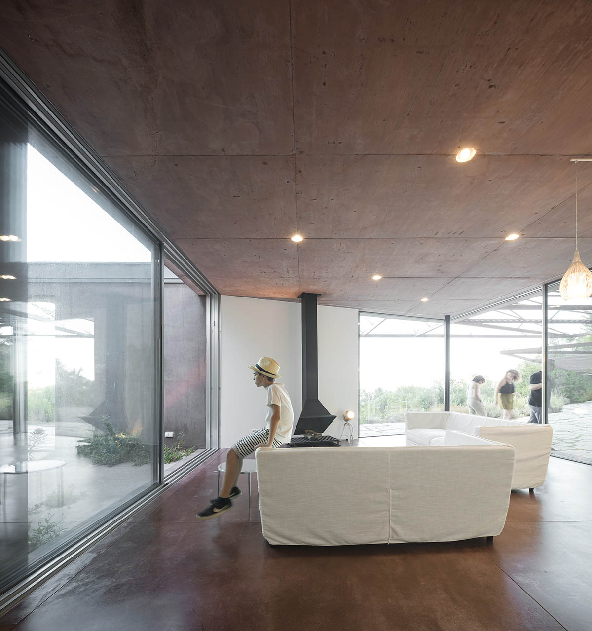 Earthy-toned twin houses by Extrastudio appear to emerge from the ground on a steep slope in Sesimbra