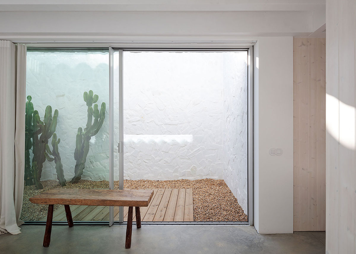 Low-profiled whitewashed stone walls wrap living units of Casa da Volta by PROMONTORIO and João Cravo