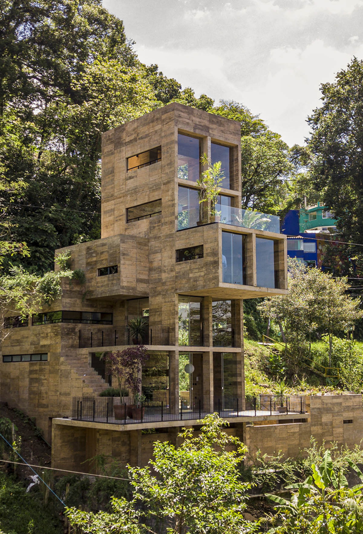 Earth-toned apartment building prioritizes views towards a forest in Coatepec, Mexico