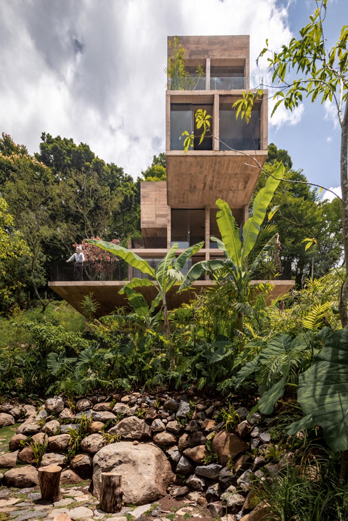 Earth-toned apartment building prioritizes views towards a forest in Coatepec, Mexico