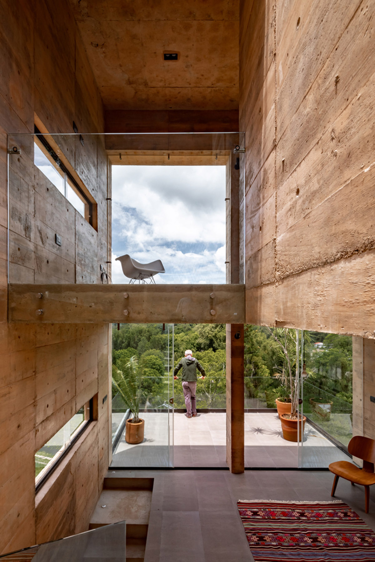 Earth-toned apartment building prioritizes views towards a forest in Coatepec, Mexico