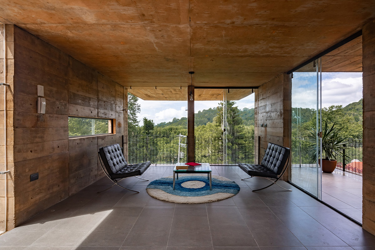 Earth-toned apartment building prioritizes views towards a forest in Coatepec, Mexico
