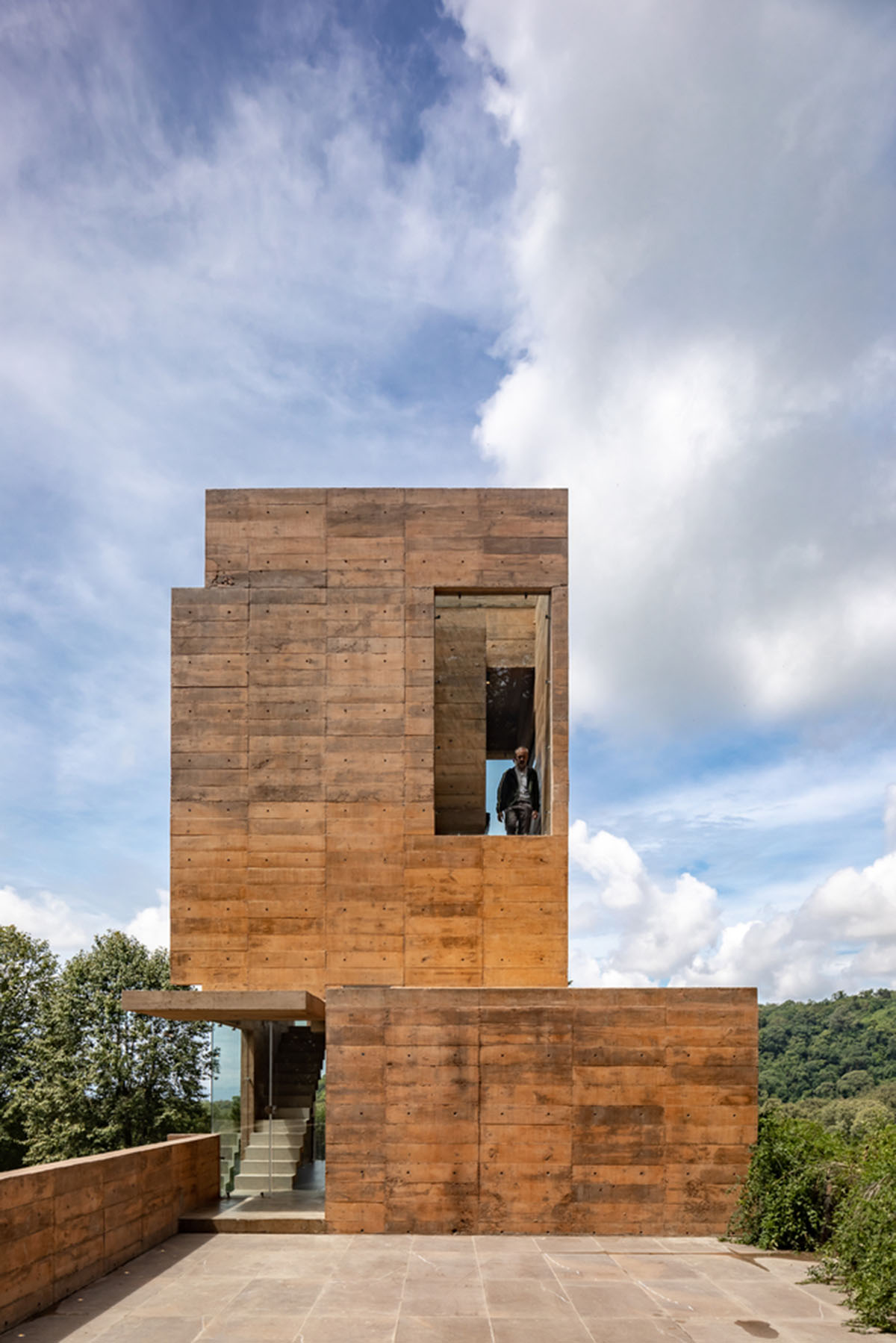 Earth-toned apartment building prioritizes views towards a forest in Coatepec, Mexico
