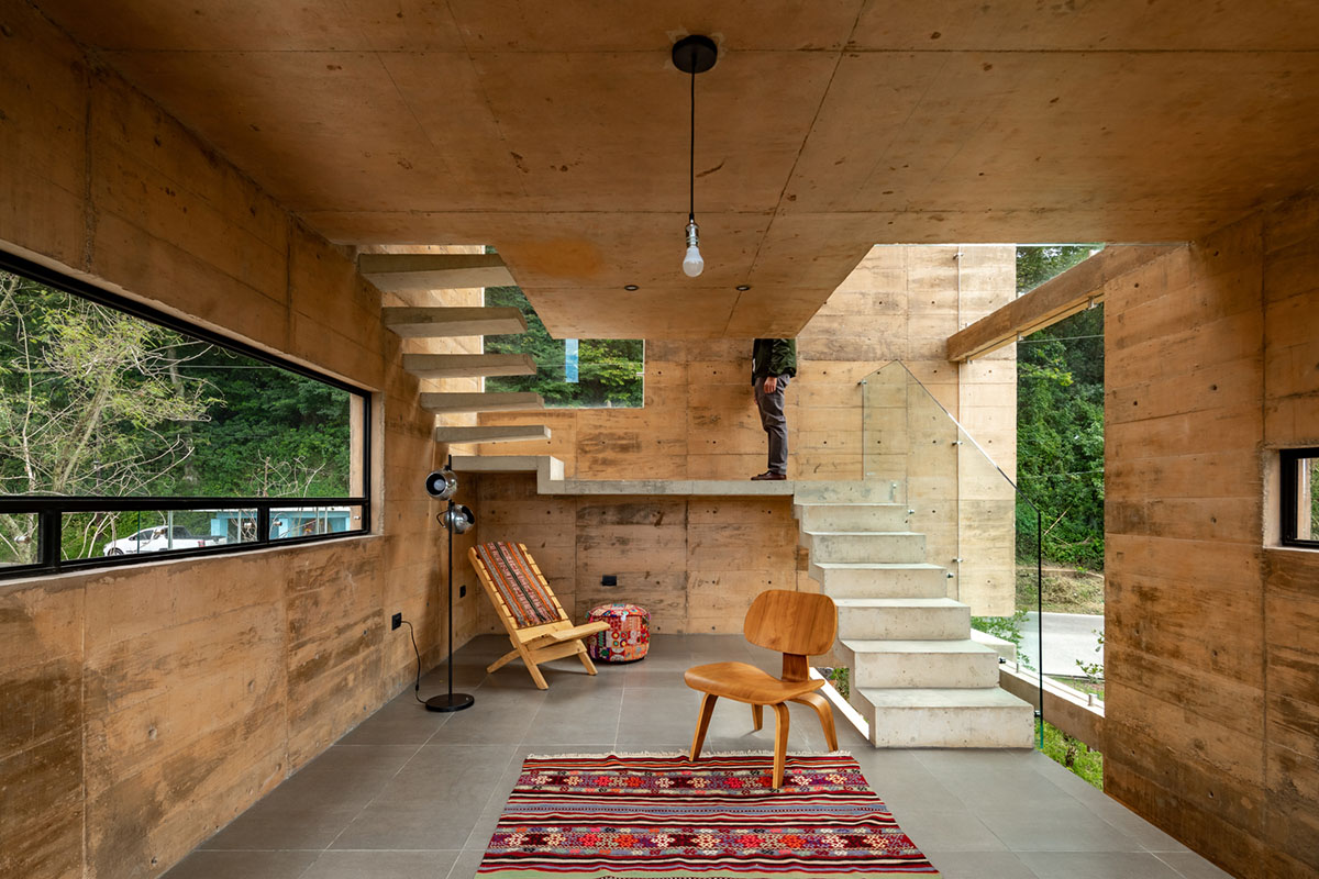 Earth-toned apartment building prioritizes views towards a forest in Coatepec, Mexico