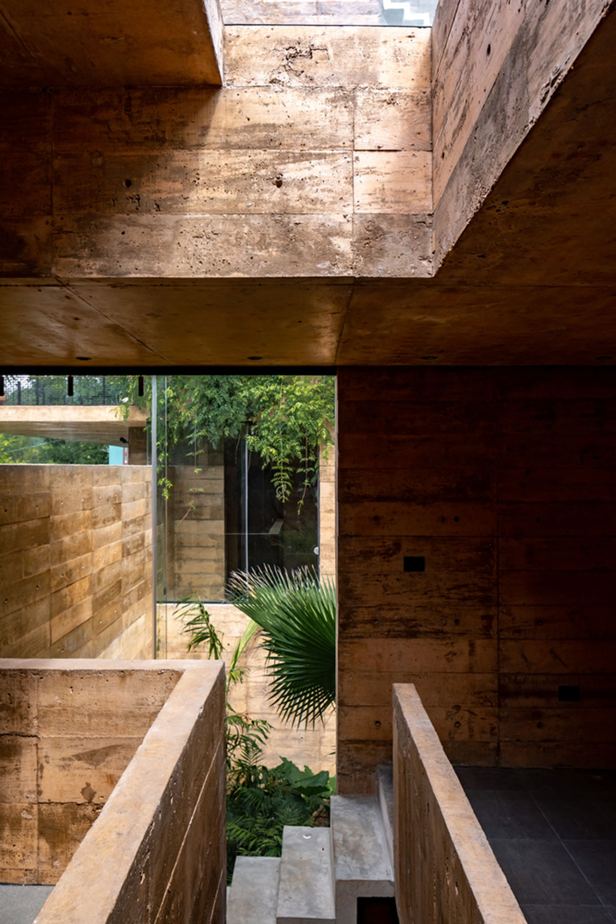 Earth-toned apartment building prioritizes views towards a forest in Coatepec, Mexico