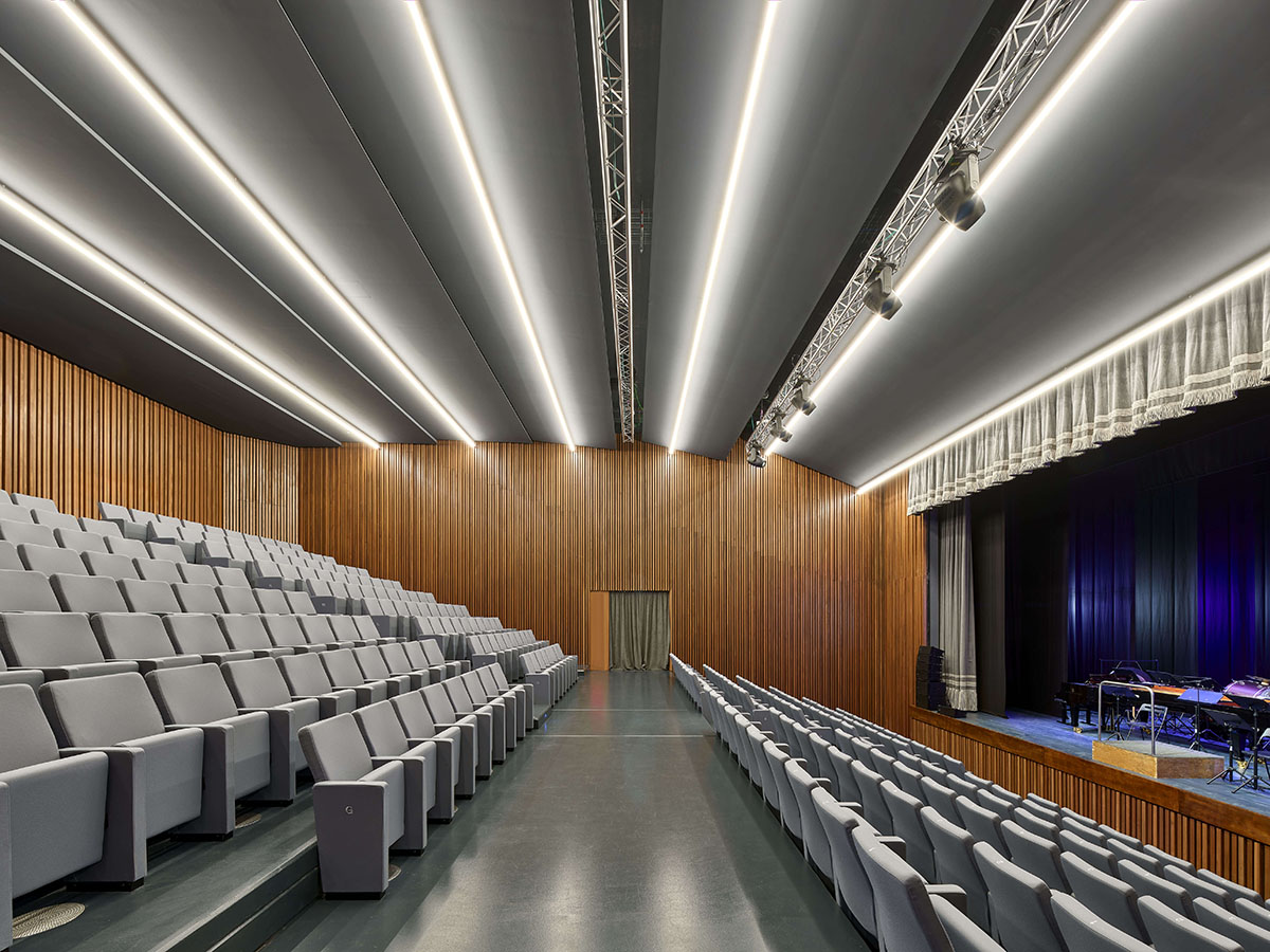 Teatro Borsoni theater is wrapped by façades that feature 3D-punctuated concrete blocks in Italy