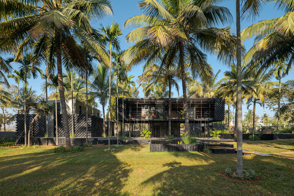 Parallax designs black weekend house raised on slender stilts within coconut trees in Bangalore