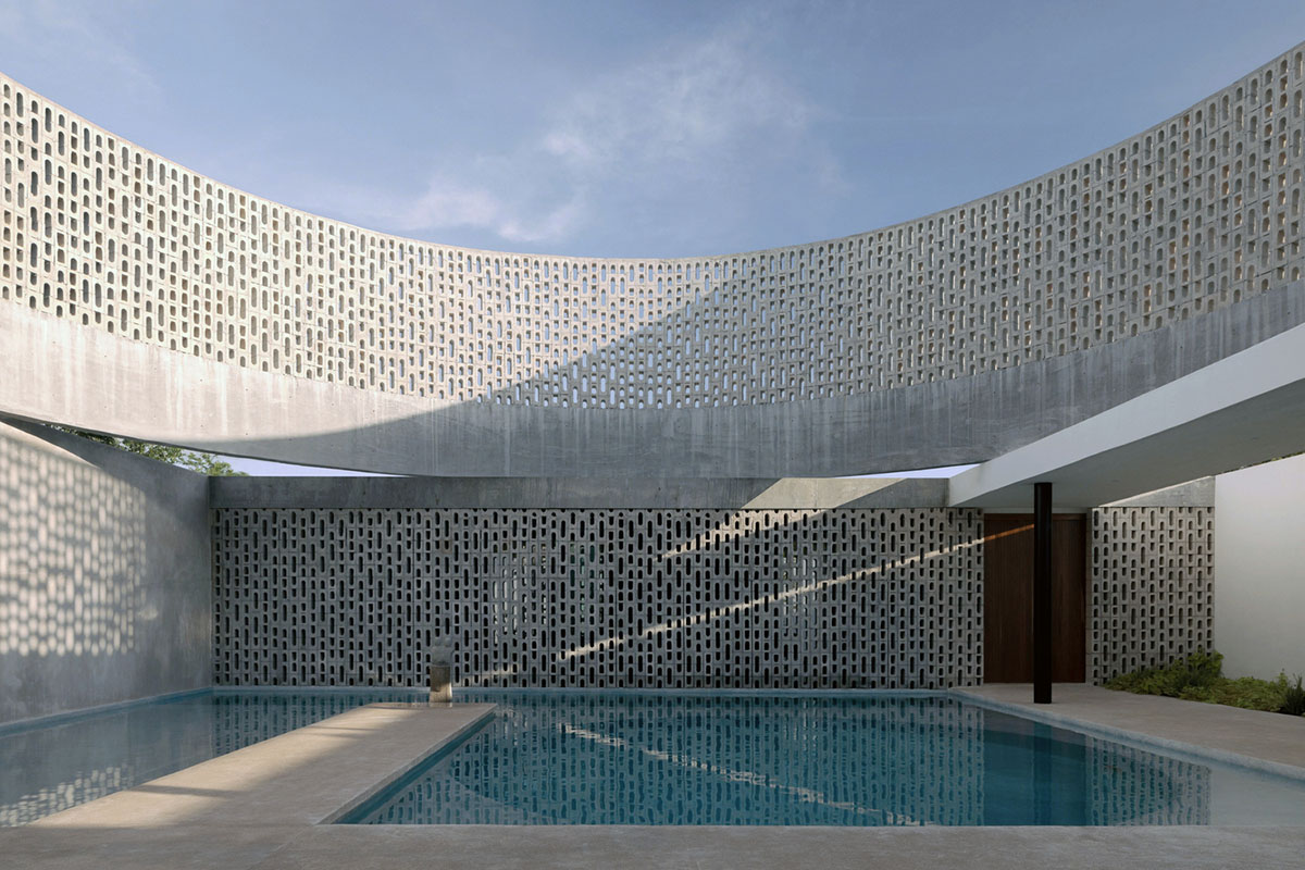 Perforated walls and cylindrical courtyard provide play of light in Wóolis House in Mexico
