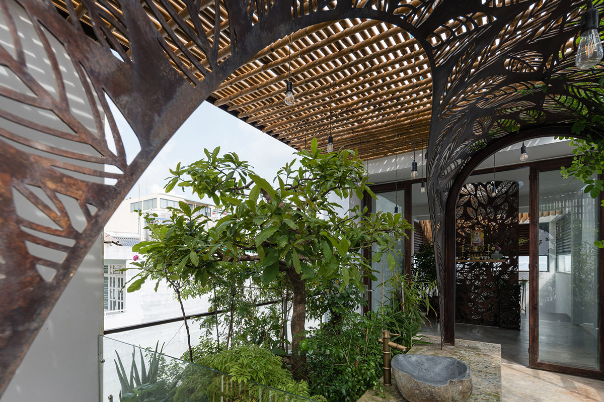 This Vietnamese narrow house by atelier NgNg is clad by woven bamboo screen made of vertical sticks