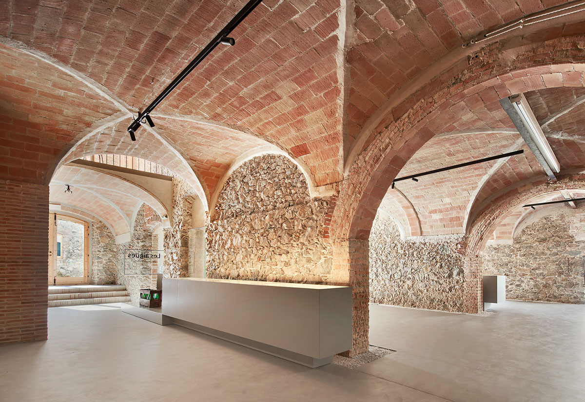 Aigua de Vilajuïga restored with vaulted bricks and exposed concrete bringing light into the space