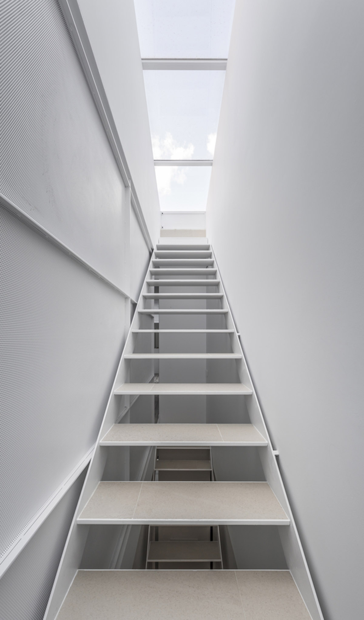 Viraje arquitectura creates perforated façade for elongated family house to play with natural light