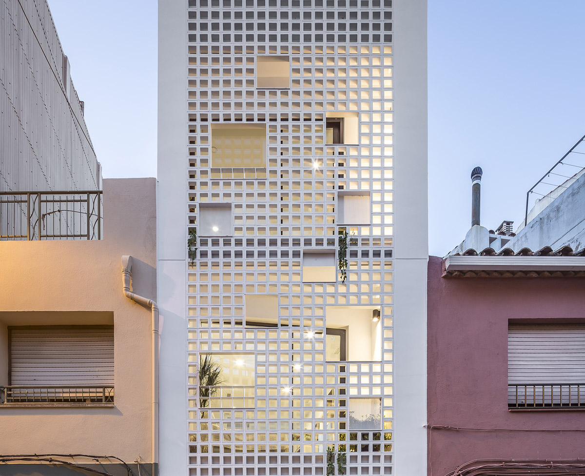 Viraje arquitectura creates perforated façade for elongated family house to play with natural light