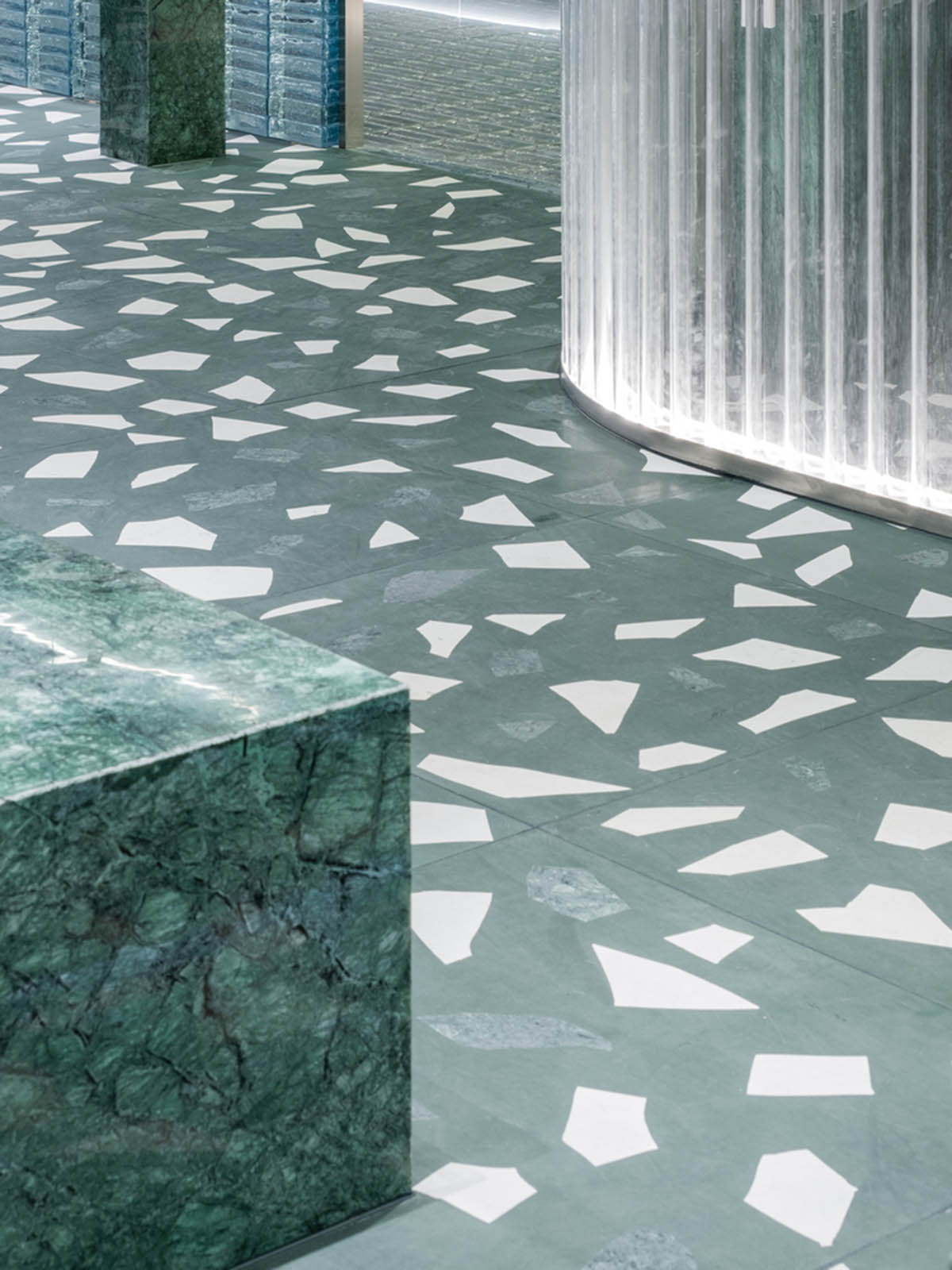 Studio 10 designs fashion store combining different hues of green color with reflective surfaces