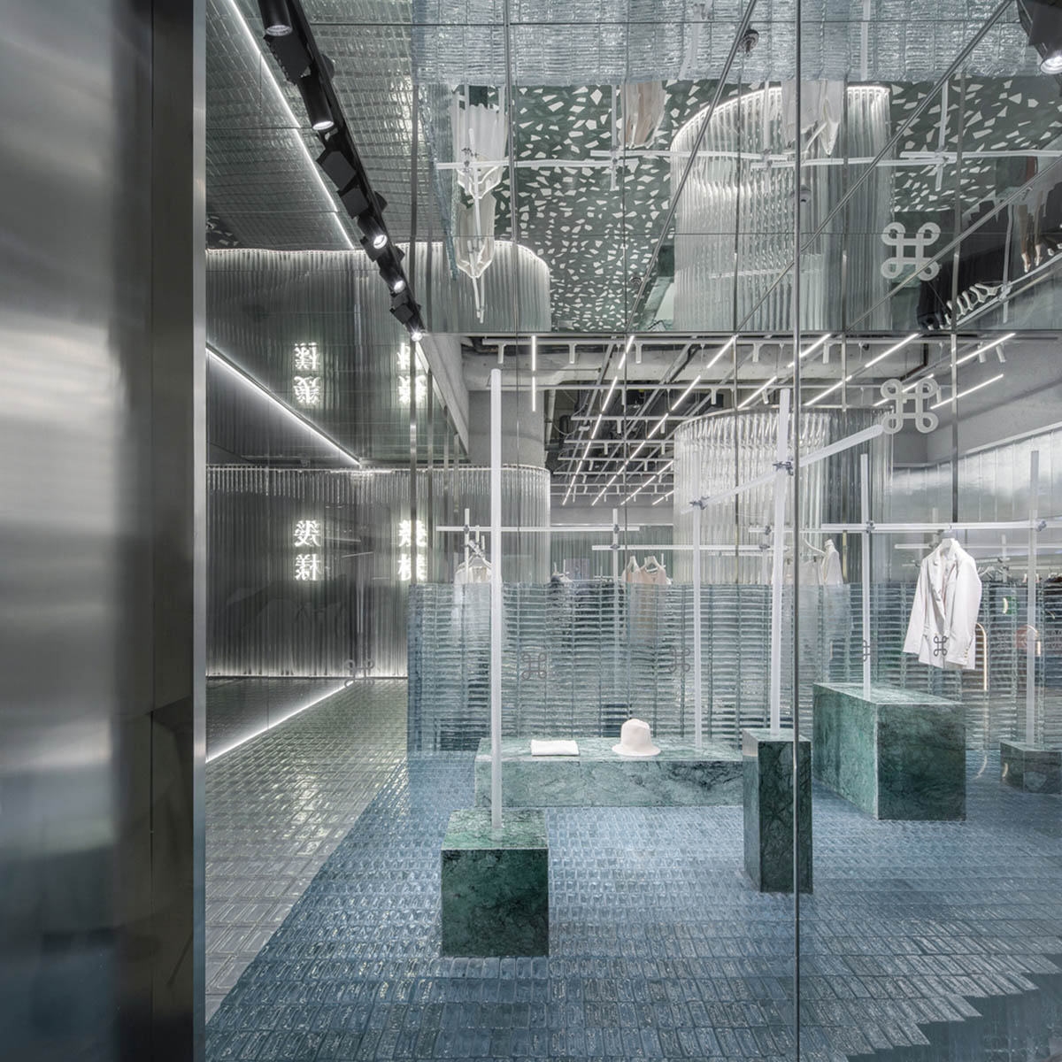 Studio 10 designs fashion store combining different hues of green color with reflective surfaces