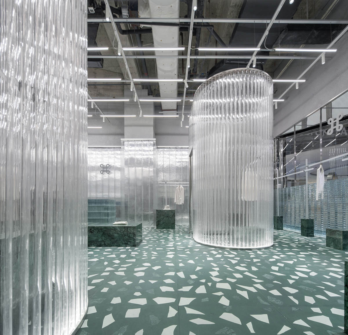 Studio 10 designs fashion store combining different hues of green color with reflective surfaces