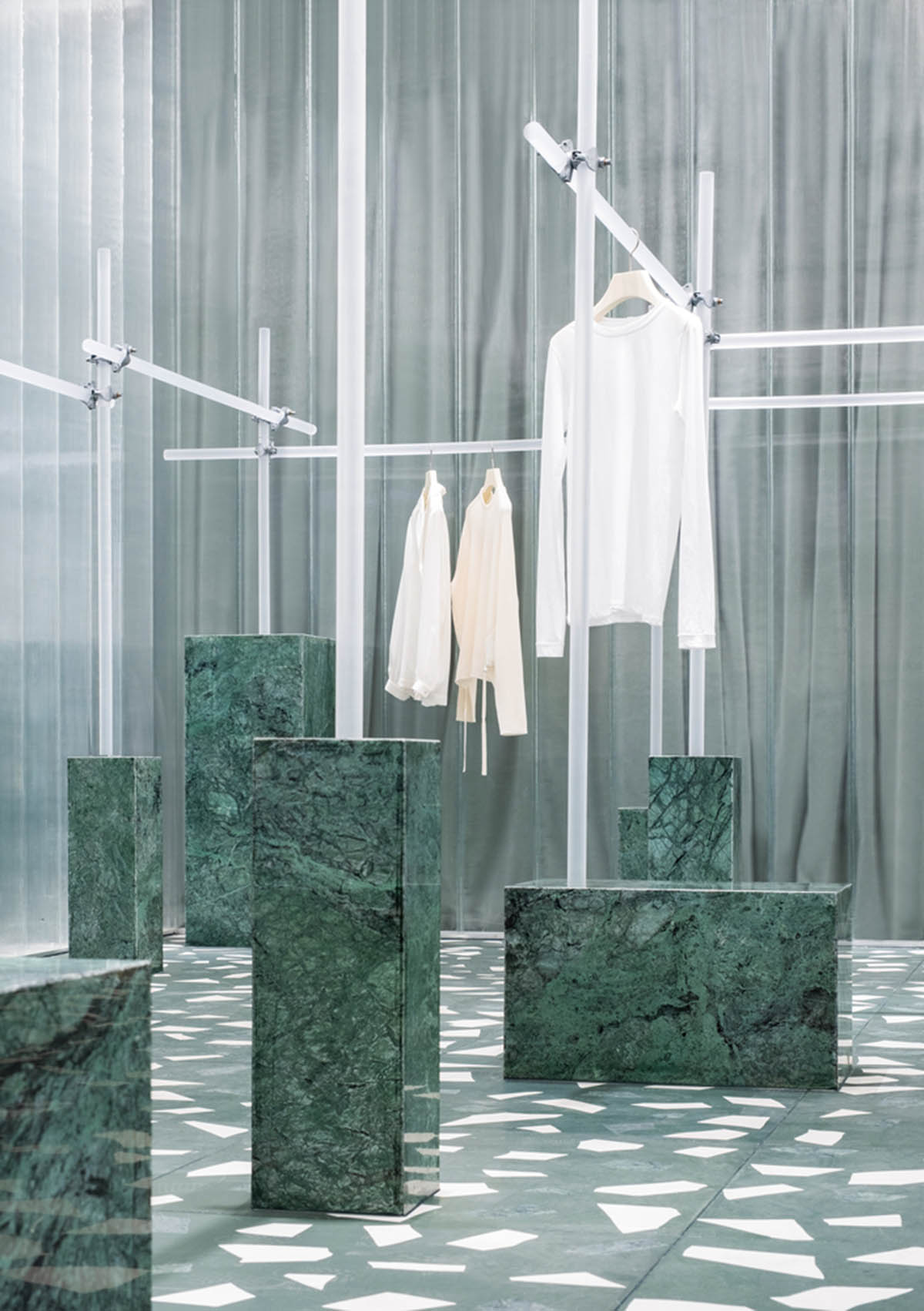 Studio 10 designs fashion store combining different hues of green color with reflective surfaces