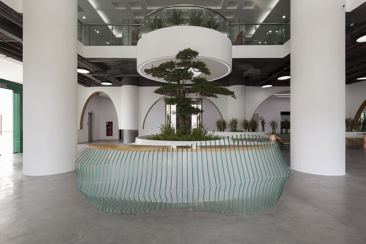 Copper-colored staircase and mini-bamboo trees provide tropical interior for this office in Vietnam