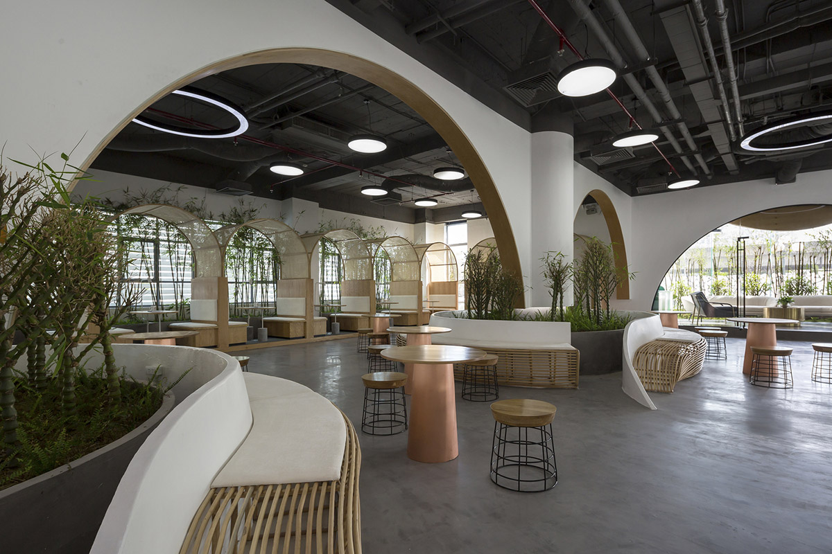 Copper-colored staircase and mini-bamboo trees provide tropical interior for this office in Vietnam