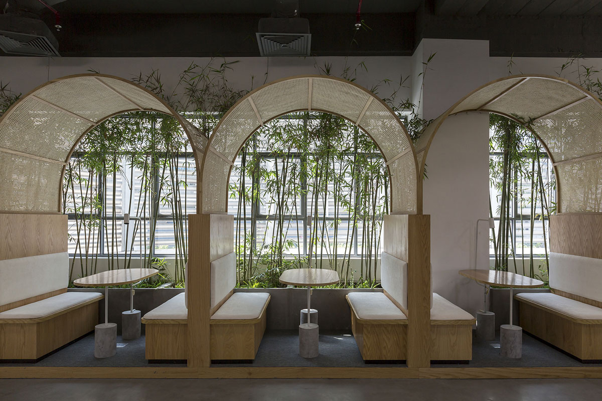 Copper-colored staircase and mini-bamboo trees provide tropical interior for this office in Vietnam