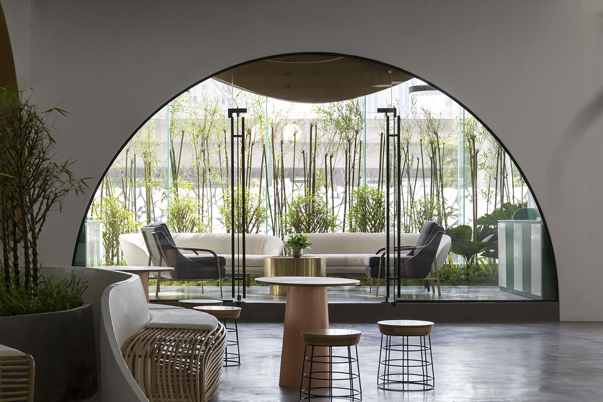 Copper-colored staircase and mini-bamboo trees provide tropical interior for this office in Vietnam