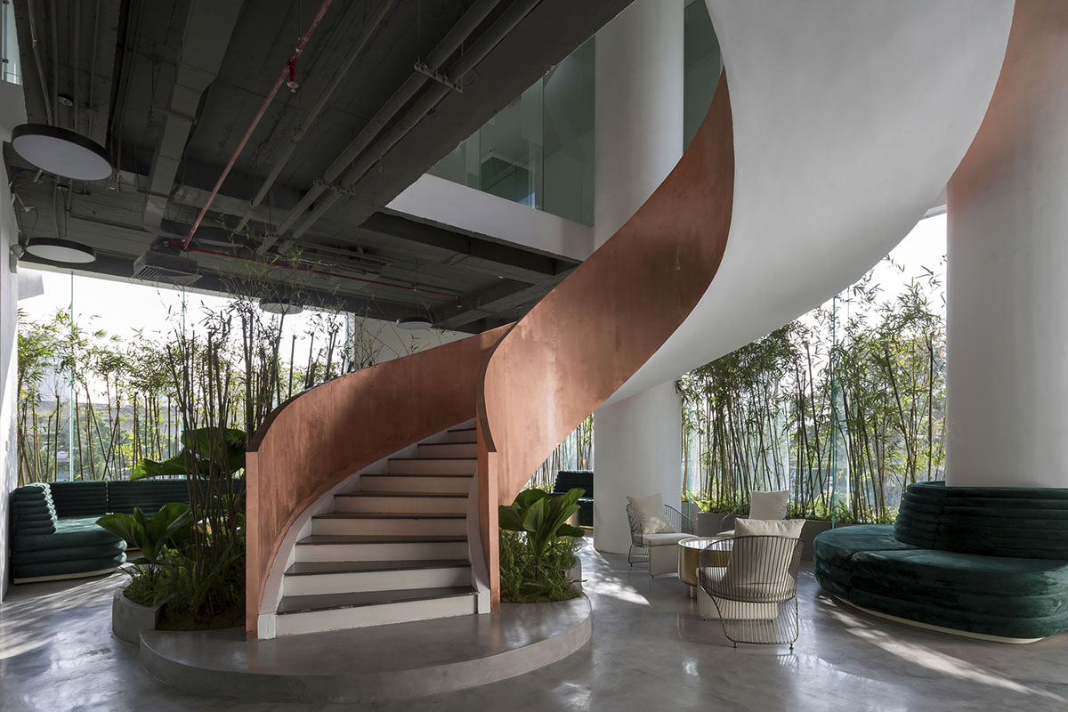 Copper-colored staircase and mini-bamboo trees provide tropical interior for this office in Vietnam