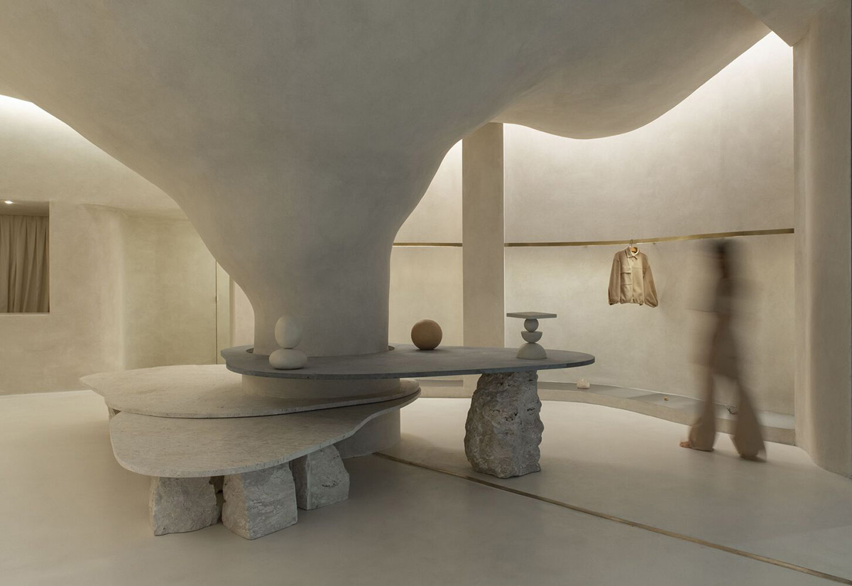 Giant organically-shaped pillar becomes a showcase element in the heart of clothing store in Brazil