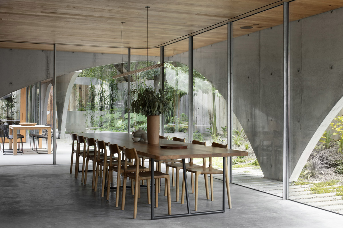 Arched concrete walls wrap a pair of houses as a secondary shelter in Australia