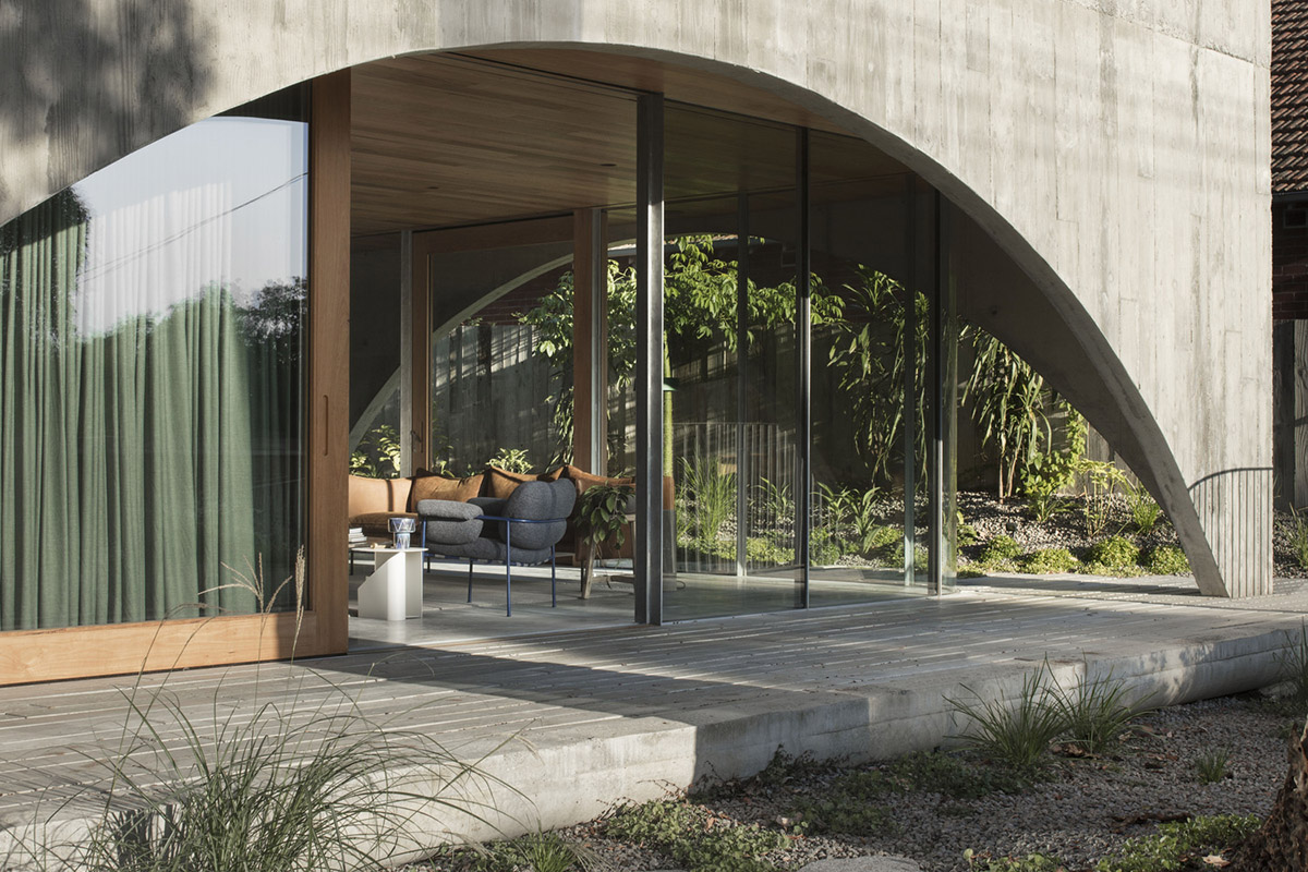 Arched concrete walls wrap a pair of houses as a secondary shelter in Australia