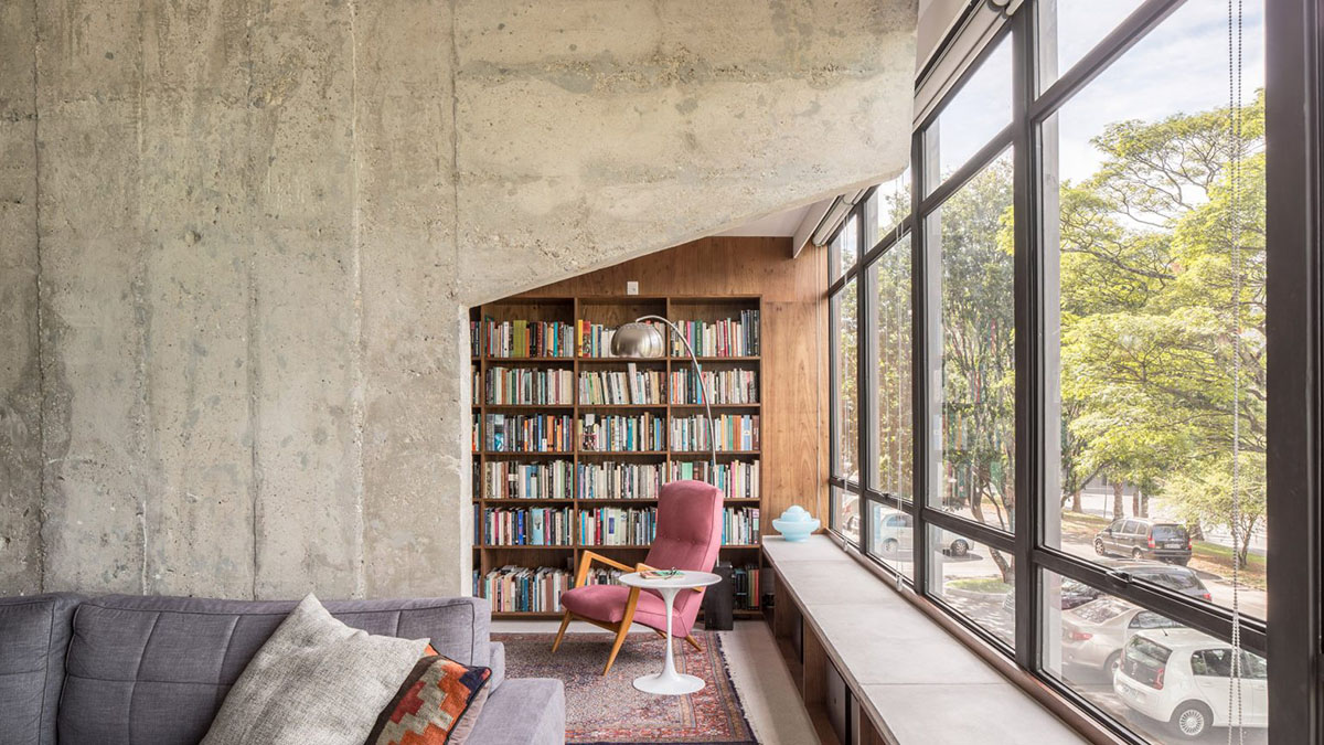 A historic Brazilian apartment has been redesigned with wooden bookcase as main divider