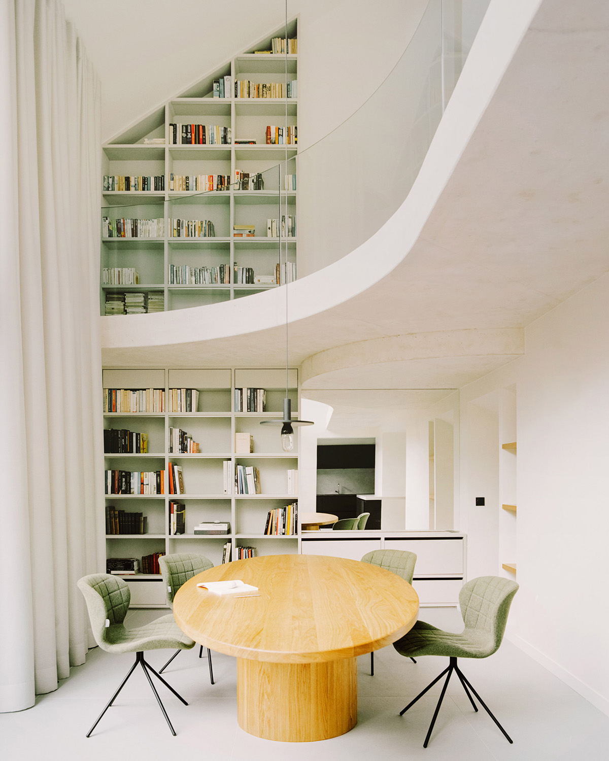 White concrete curved bridge gently complements interiors of The Island House in Paris