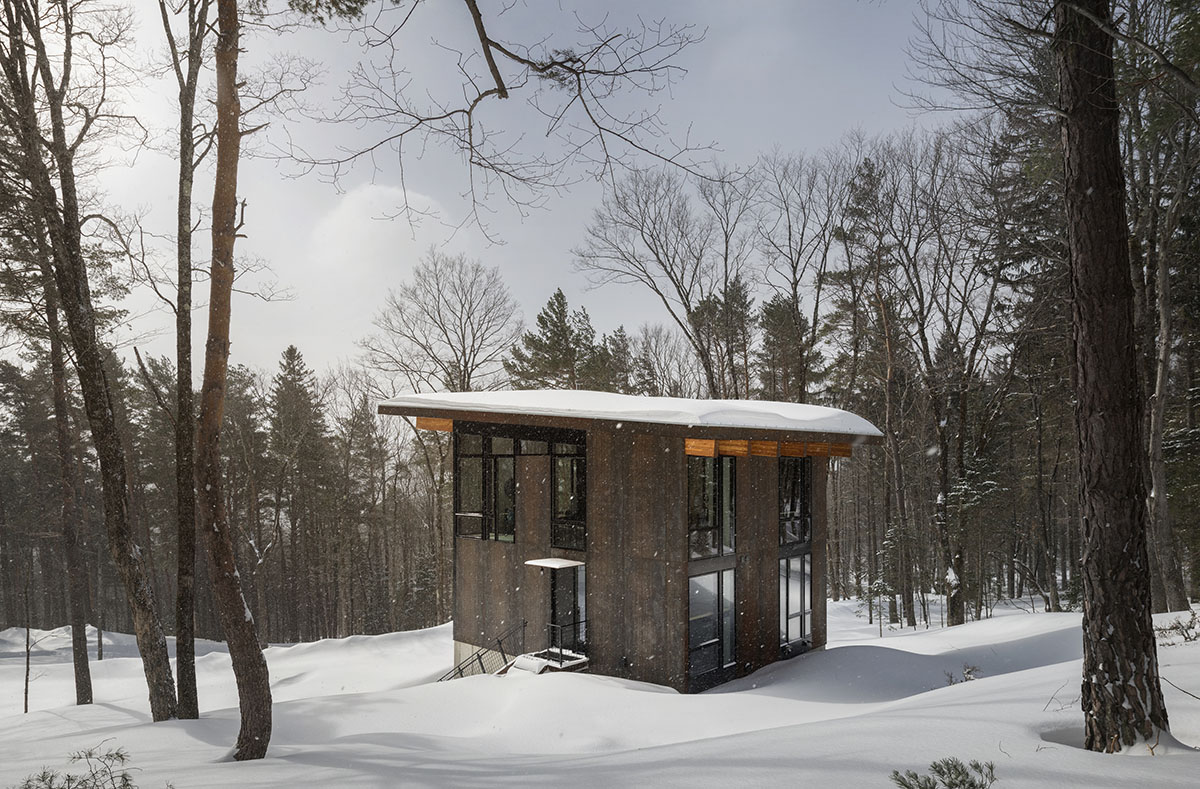 Olson Kundig creates compact and minimal family cabin in a heavily wooded landscape in Vermont 