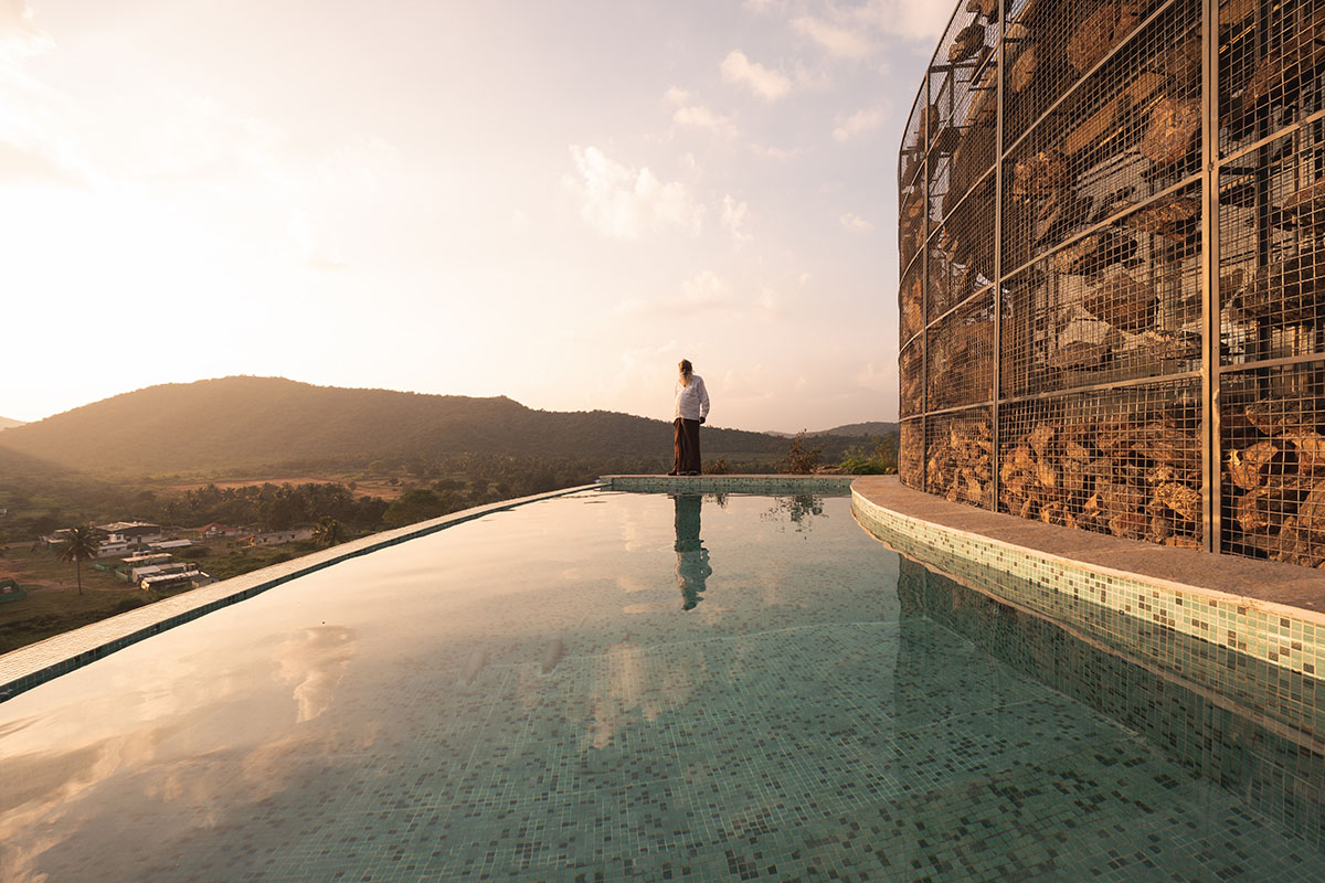 Farm house by Earthscape Studio is wrapped by gabion wall to filter light and airflow in India 