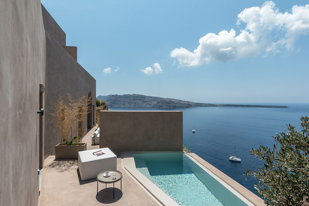 Kapsimalis Architects built castle-like hotel almost disappearing it on a steep hillside of Oia